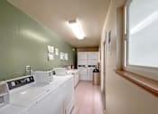 Thumbnail 12 of 16 - A laundromat with washers and dryers is shown.