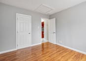 Thumbnail 8 of 38 - A room with two white doors and a wooden floor.