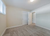 Thumbnail 15 of 29 - A room with two doors and a carpeted floor.