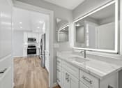 Thumbnail 48 of 67 - A modern kitchen with a white countertop and a large mirror above the sink.