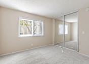 Thumbnail 22 of 51 - A room with a carpeted floor and a window with blinds.