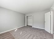 Thumbnail 33 of 33 - A room with a carpeted floor and a white door.