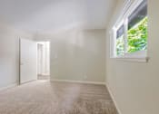 Thumbnail 32 of 37 - A room with a carpeted floor and a window letting in natural light.