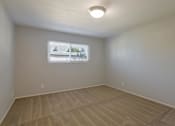 Thumbnail 9 of 29 - a bedroom with a window and a carpeted floor