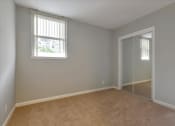 Thumbnail 22 of 35 - A room with a carpeted floor and a sliding glass door.