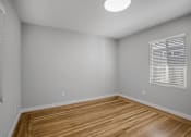 Thumbnail 8 of 31 - A room with wooden flooring and a window with blinds.