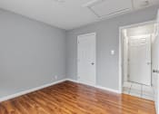 Thumbnail 30 of 38 - A room with wooden floors and two white doors.