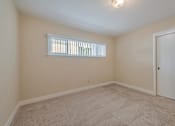 Thumbnail 27 of 29 - A room with a carpeted floor and a window with blinds.