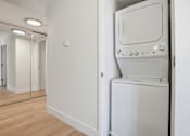 Thumbnail 82 of 92 - A white washing machine is in a small room.