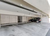 Thumbnail 42 of 43 - A black car is parked in a garage with a white ceiling.