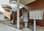 Thumbnail 20 of 42 - A mailbox is attached to a pole next to a wooden staircase.