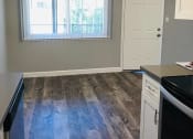 Thumbnail 3 of 7 - an empty kitchen with wood floors and a window