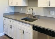 Thumbnail 4 of 7 - a kitchen with white cabinets and a sink