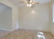 Thumbnail 24 of 34 - A room with a ceiling fan and tiled floor.