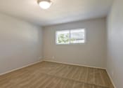 Thumbnail 8 of 29 - an empty living room with a window and wooden floors