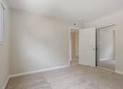 Thumbnail 16 of 37 - A room with a white door and carpeted floor.