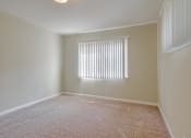Thumbnail 27 of 37 - A room with a window covered by white blinds.