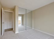 Thumbnail 19 of 33 - an empty bedroom with mirrored closet doors