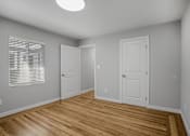 Thumbnail 1 of 31 - A room with wooden floors and white walls.