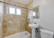 Thumbnail 22 of 38 - A bathroom with a sink, toilet, and tub.