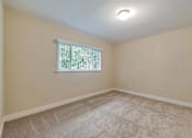 Thumbnail 11 of 29 - A room with a window and carpeted floor.