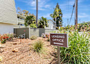 Thumbnail 24 of 43 - A brown sign that says Leasing Office stands in a yard.