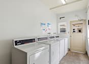 Thumbnail 21 of 33 - A laundry room with washers and dryers.