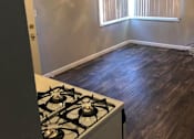 Thumbnail 25 of 31 - A room with a stove and a window with blinds.