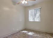 Thumbnail 33 of 34 - A room with a ceiling fan and a window with blinds.