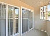 Thumbnail 26 of 27 - A patio with a sliding glass door and a window.
