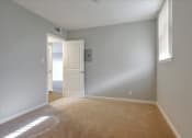 Thumbnail 24 of 35 - A room with a carpeted floor and a doorway leading to another room.
