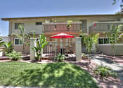 Thumbnail 2 of 51 - A building with a red umbrella in front of it.