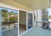 Thumbnail 87 of 92 - A balcony with glass doors leading to a patio.