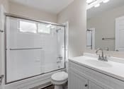 Thumbnail 36 of 51 - A white bathroom with a toilet, sink, and shower.