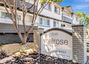 Thumbnail 2 of 43 - A sign for Melrose Apartments is in front of a building.