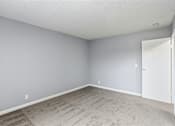 Thumbnail 40 of 55 - A room with a carpeted floor and a white door.