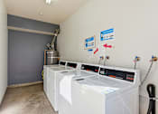 Thumbnail 29 of 33 - A laundry room with washers and dryers.
