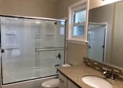 Thumbnail 19 of 62 - a bathroom with a shower and a sink and a toilet