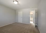 Thumbnail 6 of 29 - a empty living room with white walls and a door to a bathroom
