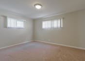 Thumbnail 25 of 37 - A room with carpeted floor and two windows.
