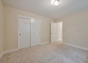Thumbnail 23 of 29 - A room with two white doors and a carpeted floor.
