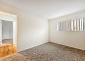 Thumbnail 28 of 43 - A room with a carpeted floor and a window with blinds.