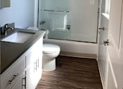 Thumbnail 12 of 37 - A bathroom with a toilet, sink, and shower.