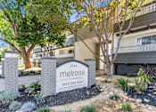Thumbnail 1 of 43 - A sign for Melrose apartments is in front of a building.