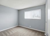 Thumbnail 41 of 55 - A room with a carpeted floor and a window with blinds.