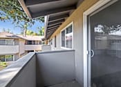Thumbnail 36 of 37 - A balcony with a glass door and a grey wall.