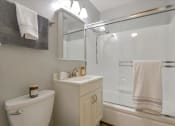 Thumbnail 26 of 35 - A white toilet sits next to a sink in a bathroom.