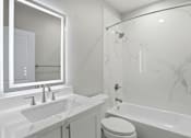 Thumbnail 54 of 60 - A white bathroom with a marble tub and sink.