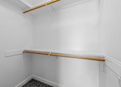 Thumbnail 33 of 92 - A white room with a wooden shelf and a carpeted floor.