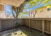 Thumbnail 29 of 51 - A patio with a tree in the background.